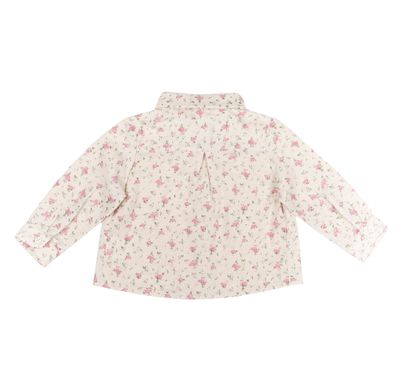 A milk-colored cotton blouse with a flower for a girl